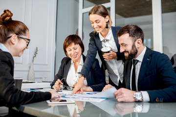 Business people working with charts and documents sitting at the table during the conference in the office