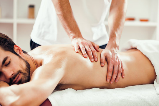 Young man is enjoying massage on spa treatment. 