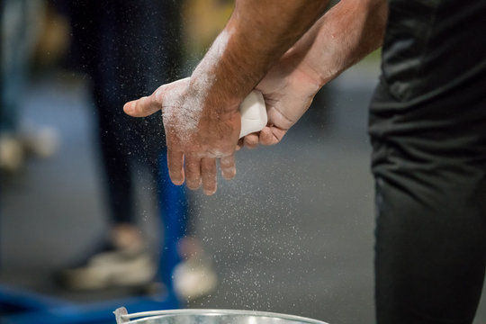 Close up selective focus of male hands preparing with chalk magnesium before exercise.