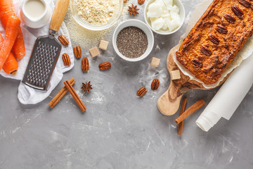 Healthy alternative vegan carrot cake, vegetarian pastries ingredients: chia, coconut butter, almond milk, nuts. Carrot bread, light background. Healthy vegan food concept. Top view
