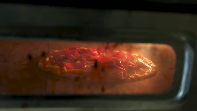 Meat pizza in the oven. Food being baked close up.