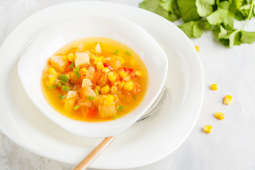 Healthy spring vegetable corn soup in a white plate. Vegan Healthy Food Concept. Top view