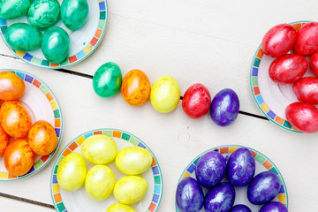 Easter eggs on wooden background. Colorful eggs in different colors - red, yellow, orange, purple and green.
