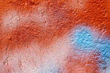 Red and blue spray painted concrete wall as abstract texture background.