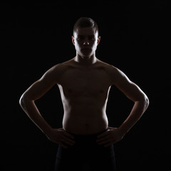 Naklejka premium The silhouette of the torso of a male athlete on a dark background.