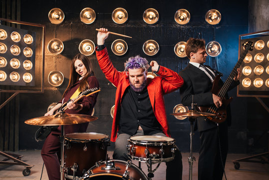Musicians in suits on stage with lights, rock band