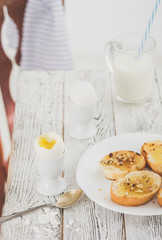 Breakfast with boiled egg, milk and fried bread.