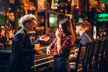 Young man talks with woman at the bar counter