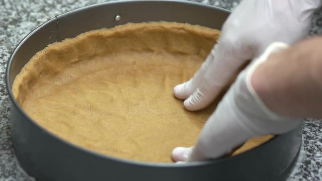 Chef hands pressing pie crust. Close up flaky pie crust kneading in form.
