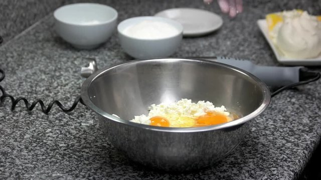 Adding yolk ingredient to the bowl. Pouring yolks in bowl with cottage cheese. Cooking dough.