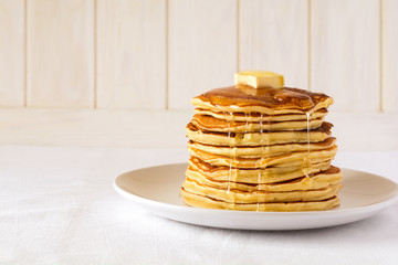 Stack of pancakes with butter and honey on white background - obrazy, fototapety, plakaty