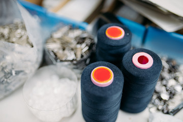 Fototapeta na wymiar Black threads on spools closeup, sewing material