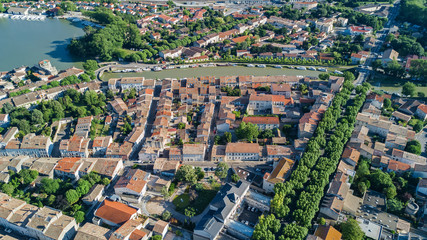 Aerial top view of Castelnaudary residential area houses roofs, streets and canal with boats from above, old medieval town background, France
