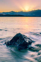 Large rock in gentle wave