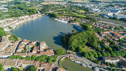 Aerial top view of Castelnaudary residential area houses roofs, streets and canal with boats from above, old medieval town background, France
