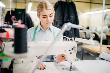 Fototapeta na wymiar Dressmaker sews fabrics on a sewing machine