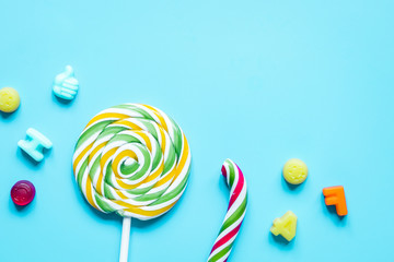 lollipop design with sugar candys on blue background top view mo