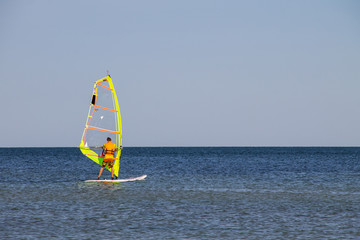 Windsurfing. Surfer exercising in calm sea or ocean.