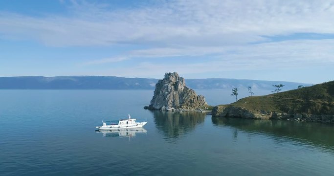 White ship in calm bay at great lake.Tranquil Aerial View of the Baikal Bay Shamanka. Olkhon Island, BaikalDrone footage.