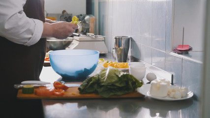 Male chef preparing salad in commercial kitchen - cleans the cabbage