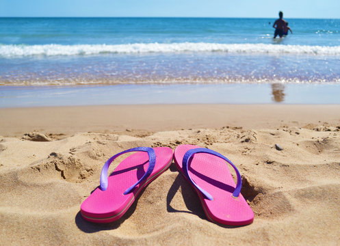 pink flip flops at a greek beach - greek summer destination
