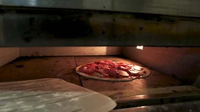 Pizza in the oven. Dough, sausages and vegetables.