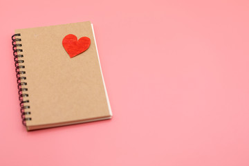 Paper red heart and Blank notebook with Pink Pastel plastic texture background. Valentine concept. Minimal concept