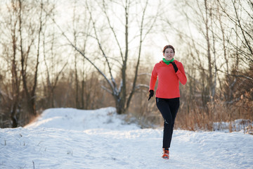 Brunette athlete running in winter park on morning run