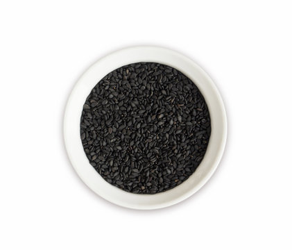 Black sesame on white background. Top view. Black sesame in a bowl isolated on white background. Sesame with copy space for text.