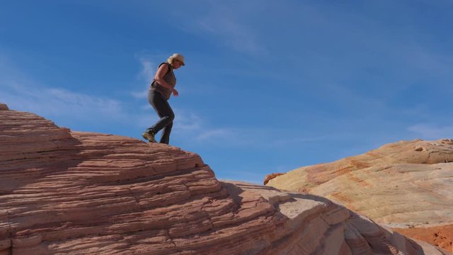 Tourist Woman Hiking Down The Crest Hill With Colorful Red Rocks Slow Motion 4K