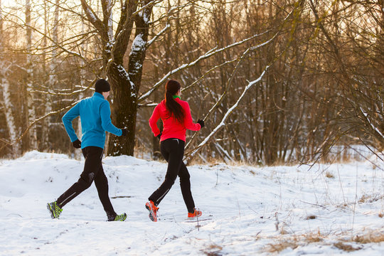 Picture from back of sports man and woman on morning run in winter