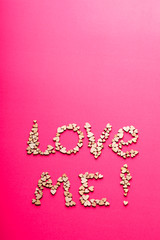 Word LOVE ME! made from wooden heart shapes 