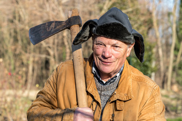 Portrait of Senior man with ax over his shoulder.