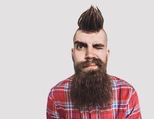 Young trendy man portrait. Excited punk man with Mohawk hairstyle. Isolated on gray background - obrazy, fototapety, plakaty