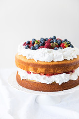 Beautiful, fruit naked cake over a white wall