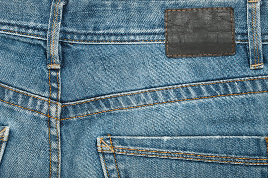 Jeans. Blue Pants Jeans With Blank Brown Label Textured Background Close Up.