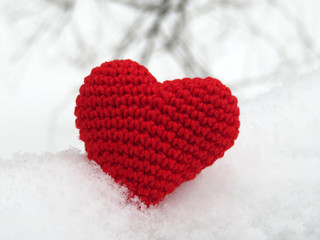 Fototapeta premium Donation background. Knitted heart in the snow on winter background. Love concept