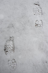 Traces of hiking shoes in the snow. A walk through the fresh air in the mountains