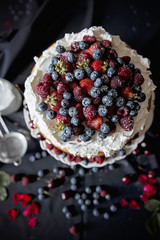 Beautiful, fruit naked cake on a dark tablecloth 