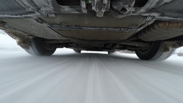 Camera below car while driving on winter road