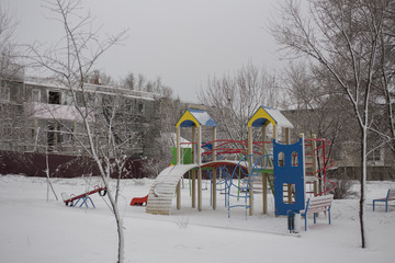Playground in winter. Winter is a nuisance for children. The snow on the playing apparatus.