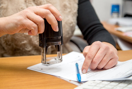 female hand with stamp prepare to execute print