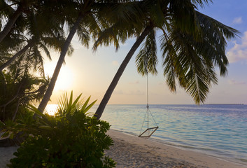 Sonnenuntergang am Maledivenstrand mit Hängeschaukel