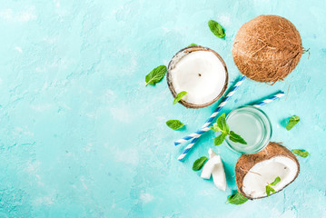 Healthy food concept.  Fresh Organic Coconut Water with coconuts, ice cubes and mint, on light blue background, copy space