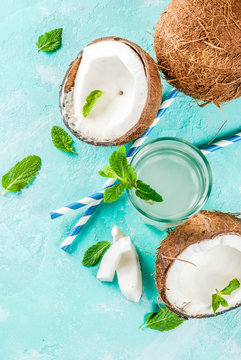 Healthy food concept.  Fresh Organic Coconut Water with coconuts, ice cubes and mint, on light blue background, copy space