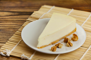 classic cheesecake on white plate on  wooden table