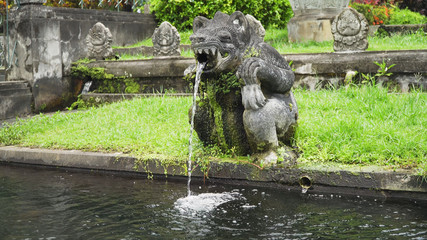Hindu Balinese Water Palace Tirta Gangga with statues of the gods, fountains in the form of a wild boar on Bali island, Indonesia. Tirta Gangga the former royal water palace is a maze of pools and