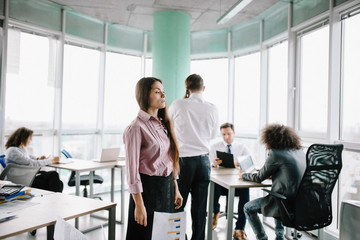 Young woman standing desperately in middle of office. Has troubles with tasks.