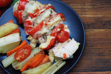 Healthy Roast Chicken Meat Breast with Tomatoes and Vegetables. Dark Wooden Background.