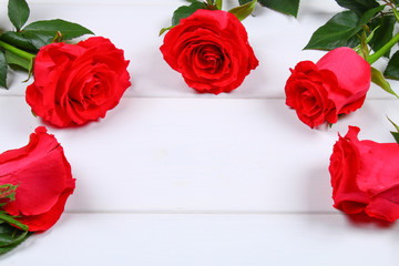 Pink roses on a white wooden table. Copy space for text. Template for March 8, Mother's Day, Valentine's Day.